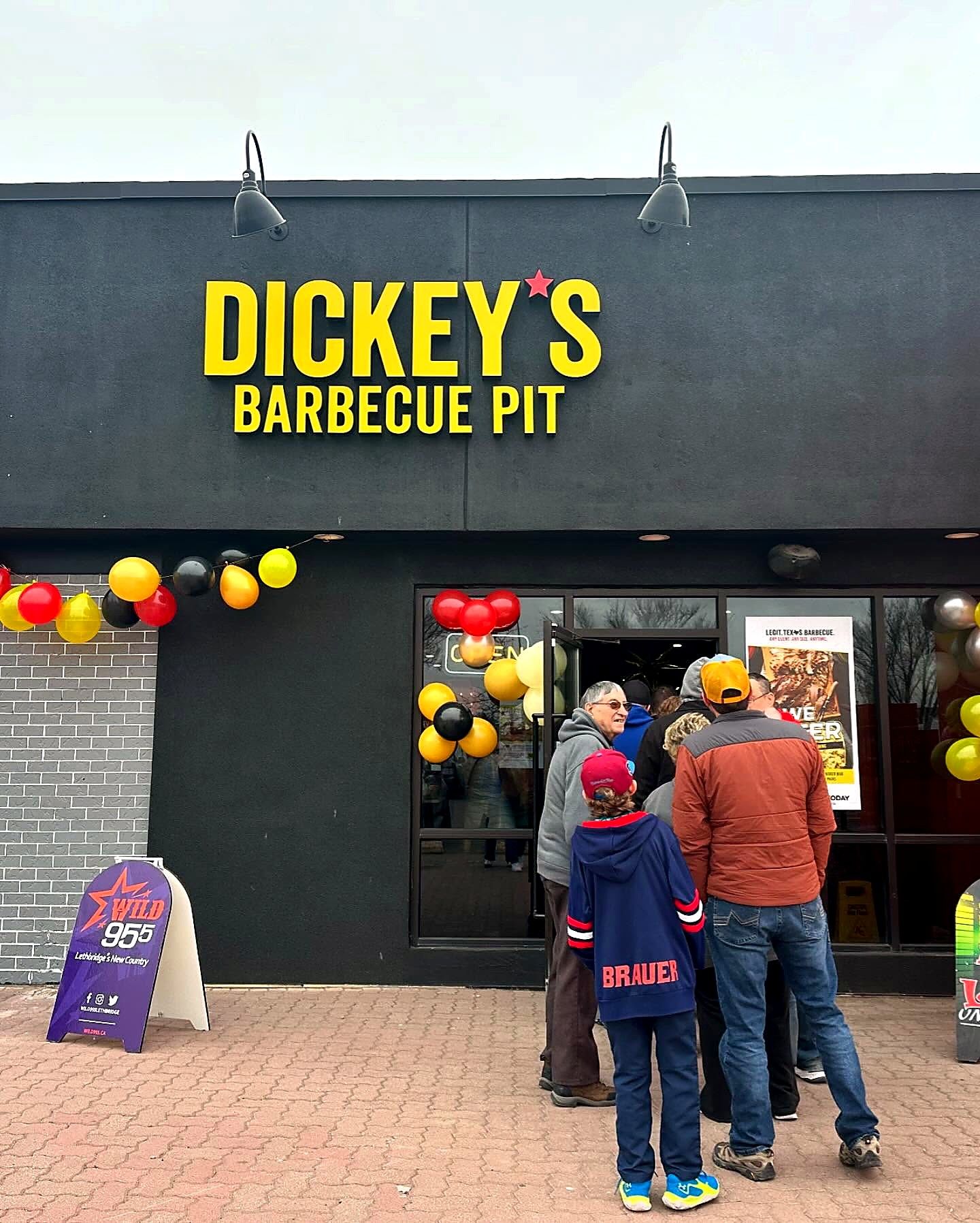 Dickey's Barbecue Pit storefront sign in yellow letters on a black fascia