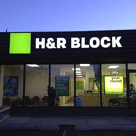 H&R Block illuminated storefront sign at dusk